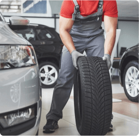 Mecânico manuseando o pneu de um carro